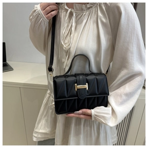 Détail du sac matelassé noir avec fermoir en H doré et bandoulière en similicuir