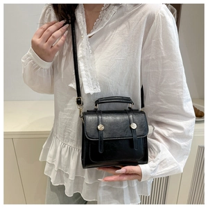 Détails d'un sac cartable vintage en cuir PU noir avec boucles argentées et sangles