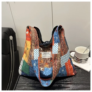Detail of colorful patchwork denim tote bag with FASHION label on rustic chair