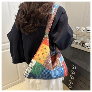 Detail of bohemian rainbow patchwork denim tote bag with geometric folding and ribbon closure