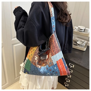 Detail of colorful patchwork canvas tote bag with geometric patterns and shoulder strap