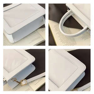 Macro view of white PVC tote featuring transparent window and gold hardware hooks