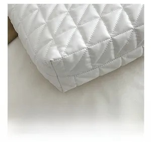 Close-up of precise diamond quilting and fine stitching on white tote bag