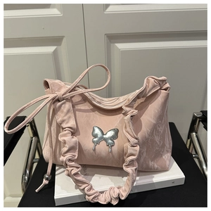 Gros plan sur le sac plissé rose avec un détail de breloque papillon en métal argenté