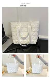 Detail of white quilted tote bag featuring a rhombic pattern and wide shoulder straps