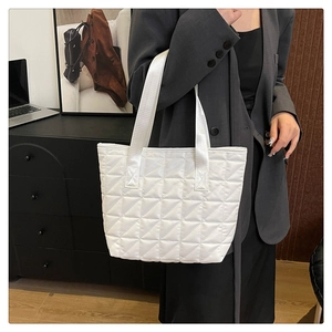 Quilted tote bag showing white rhombic stitching and wide shoulder straps detail
