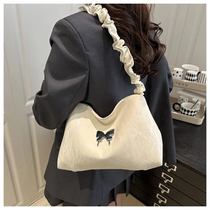 Détail d'un sac cabas blanc crème avec boucle papillon argentée et bandoulière froncée