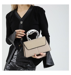 Detail of contrast stitch handbag with woven texture and organic metal handle