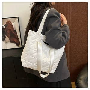 Close-up of white quilted tote bag featuring elegant diamond stitching and spacious design