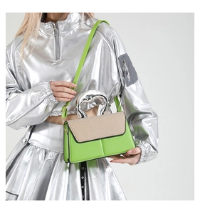 Fashionable bright green contrast handbag with silver sculptural metal handle on model