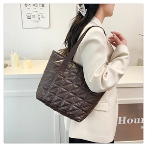 Quilted dark brown tote bag styled with a beige blazer for a trendy commute look