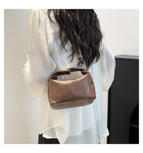 Detail view of the brown leather patchwork bag with a vintage gold metal buckle and strap