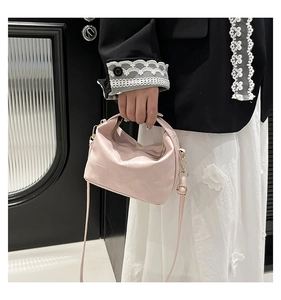 Close-up of pink soft leather tote bag with fine texture and adjustable metal buckle strap