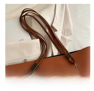 Détail du sac cabas en cuir marron avec poignée multibrins et anneau en métal