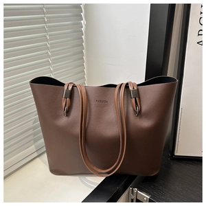 Détail du lettrage FASHION gaufré et texture cuir mat sur un sac cabas marron