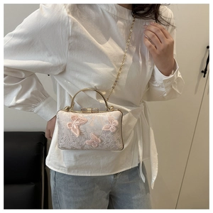 Detail of pink satin evening bag featuring 3D butterfly appliqués and floral embroidery