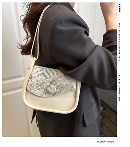 Detail of vintage cream shoulder bag featuring traditional Chinese landscape embroidery