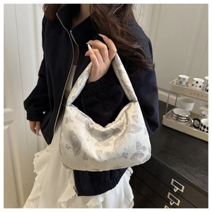 Détail du tissu jacquard papillon argenté et de la fermeture éclair métallique du sac