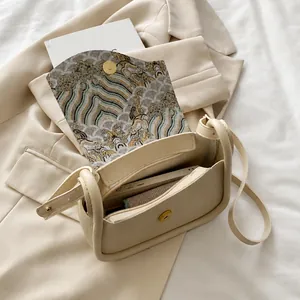 Interior view of cream saddle bag showing storage space for phone and wallet with wave liner