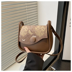 Close-up of vintage brown leather crossbody bag with Chinese brocade embroidery pattern
