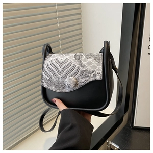 Detail of Chinese style wave pattern jacquard and button on black leather crossbody bag