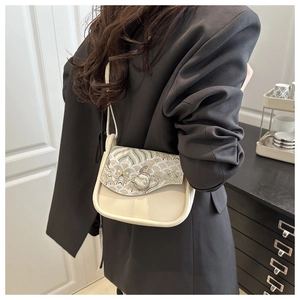 Detalle de patrones de nubes bordados en bolso crema de estilo chino moderno con bandolera