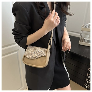 Close-up of ethnic jacquard saddle bag with embroidery detail and leather strap