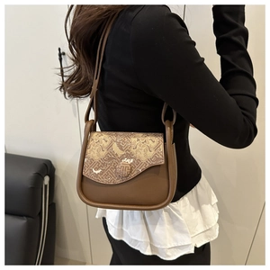 Detail of vintage brown shoulder bag with traditional golden cloud pattern jacquard flap