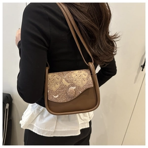 Detail view of the brown shoulder bag featuring retro jacquard pattern on the flap cover