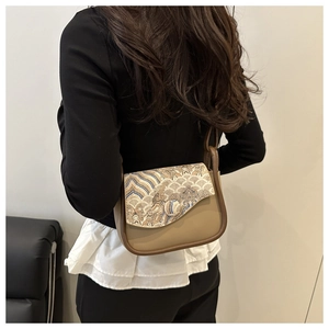 Detail of vintage embroidered small square bag with traditional patterns on crossbody strap