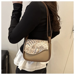 Detail of vintage Chinese embroidery patterns on a small khaki crossbody shoulder bag