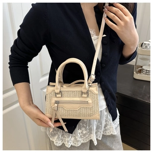 Vista laterale dettagliata della borsa intrecciata beige con nappe lunghe e tracolla