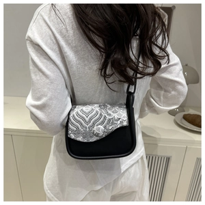 Detail of a vintage Chinese style crossbody bag with embroidery on a white outfit