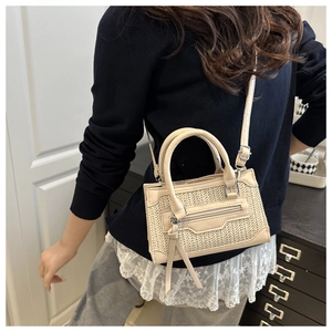 Détail du sac bandoulière crème matelassé avec texture tissée porté par un mannequin