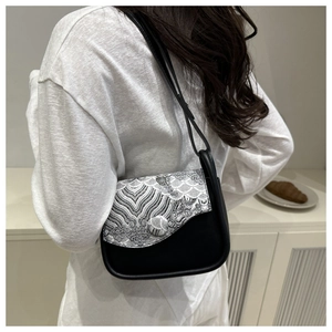 Close-up of black retro shoulder bag featuring white wavy pattern jacquard detail