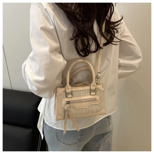 Détail du sac bandoulière crème avec tissage en paille et contraste en similicuir
