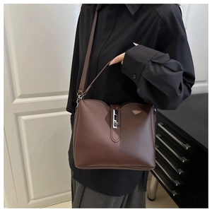 Detailed view of the dark chocolate leather tote bag with silver buckle on a model