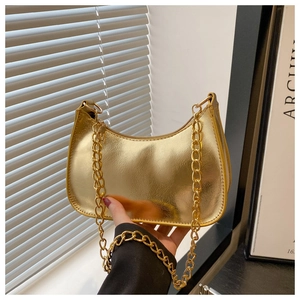Close-up of golden mirror finish crescent bag with chunky metal chain strap