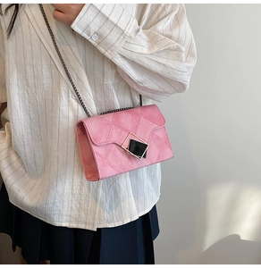 Detail view of pink quilted leather crossbody bag with elegant chain strap and metal buckle