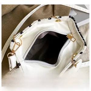 Dettaglio della borsa a tracolla in tweed bianco e nero con scomparto interno e zip