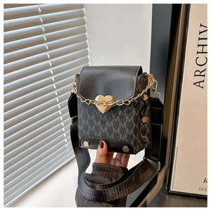 Detalle de mini bolso bandolera retro con hebilla de corazón, remaches y correa ancha
