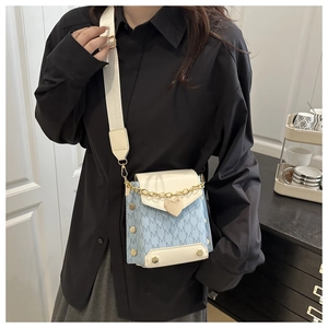 Detail of blue PU leather square bag with M-pattern print and gold chain strap