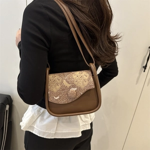Brown vintage leather crossbody bag with Chinese embroidery pattern worn by model