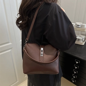 Dark brown leather bucket bag with silver twist lock shown on model for daily styling