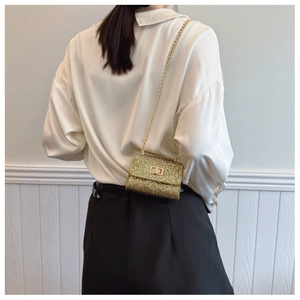 Detail of a sparkling gold mini chain bag featuring high-density sequins and a metal clasp