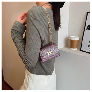 Chic burgundy sequin mini crossbody bag with gold chain strap worn by model