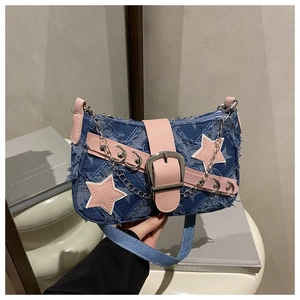 Détail du sac en jean avec garniture en cuir rose, patchs étoiles et chaîne argentée