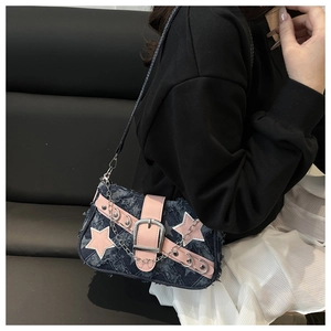 Détail d'un sac d'épaule en denim avec étoiles roses et boucle en métal sur modèle