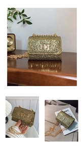 Détail d'un mini sac à paillettes dorées avec chaîne épaisse et fermoir métallique