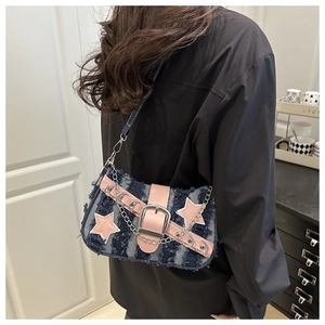 Chic denim shoulder bag with pink stars and silver chain detail shown on a model
